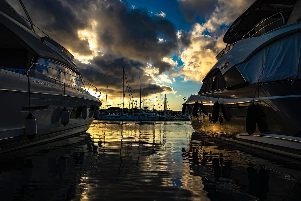 white boat on body of water under cloudy sky during daytime