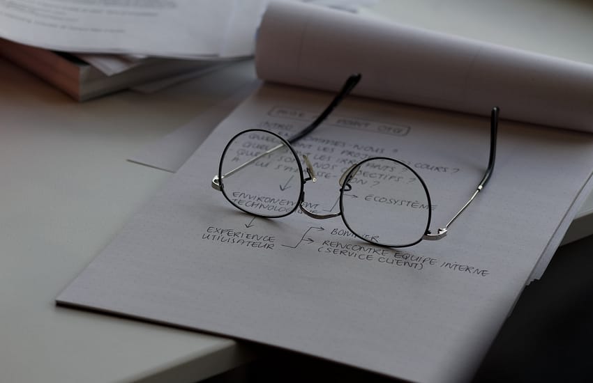 black framed eyeglasses on top of white printing paper